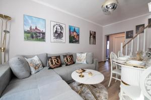 a living room with a couch and a table at The Royal House 102 sqm 2BR Two Floor Apartment in Hunedoara +30 photos