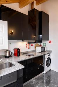 a kitchen with black cabinets and a washer and dryer at Alojamento 5 de Outubro in Amarante +7 photos
