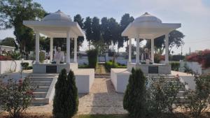 two statues in a gazebo in a garden at Vardha Greens Resort in Greater Noida