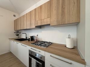a kitchen with wooden cabinets and a stove top oven at Casa Alma in Castelfranco Veneto +5 photos