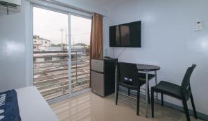 a room with a table and a television and a window at V-Cloud Hills Boarding House Near NAIA Terminal in Manila
