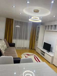ein Wohnzimmer mit Couch und Fernseher in der Unterkunft Apartment cu vedere la râu in Gura Humorului