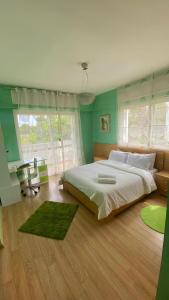 a bedroom with a large bed and green walls at spacieux villa avec terasse centre harhoura in Temara