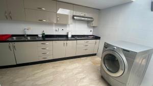 a kitchen with a washing machine and a sink at spacieux villa avec terasse centre harhoura in Temara +7 photos