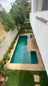 a small swimming pool in the yard of a house at spacieux villa avec terasse centre harhoura in Temara