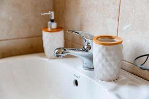 赫尔采格诺维Vila Skala的浴室水槽，配有一杯咖啡和一个水龙头