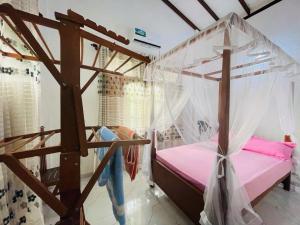a bedroom with a bed with a canopy at Veron Marina Villa in Unawatuna