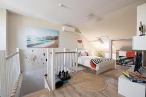 a white bedroom with a bed and a staircase at The Royal House 102 sqm 2BR Two Floor Apartment in Hunedoara