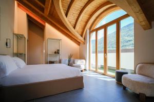 a bedroom with a bed and a large window at Sky Room Square View - 3 min walk to Bernina Express in Tirano