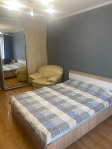 Un dormitorio con una cama, una silla y un espejo. en Чудова квартира біля ТРЦ Лавина, en Sumy