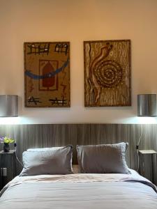a bedroom with two pictures on the wall and a bed at Rua D in Mariana +25 photos