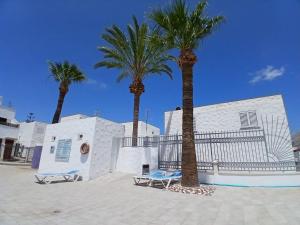 twee palmbomen voor een gebouw bij Papaya in Costa Del Silencio