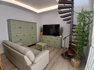 een woonkamer met een bank en een televisie bij Papaya in Costa Del Silencio