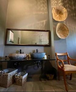 a bathroom with two sinks and a mirror and a chair at Piers Villa G in Harare