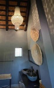 a bathroom with a sink and a chandelier at Piers Villa G in Harare
