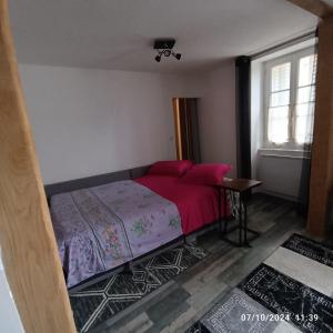 a bedroom with a bed with pink sheets and a window at Superbe appartement F3 situé au centre ville in La Charité-sur-Loire