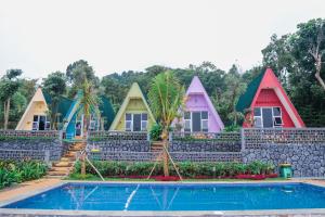 a row of colorful houses with a swimming pool at Baith Glamping in Cihideung