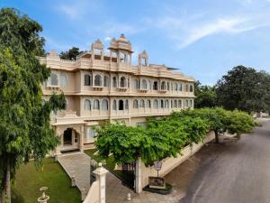 a large white building with trees in front of it at Rampratap Palace by Fateh Collection in Udaipur