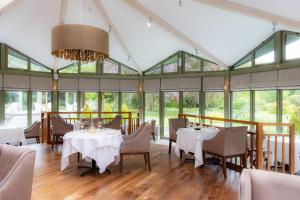 a dining room with tables and chairs and windows at Rothay Garden by Harbour Hotels in Grasmere