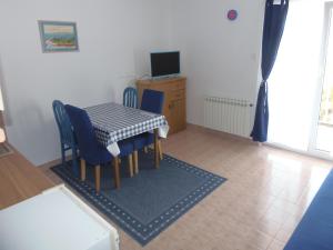 a dining room with a table and chairs and a television at Apartments Skipper in Seget Vranjica