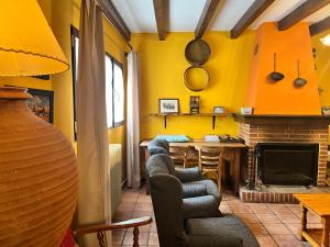 a living room with yellow walls and a fireplace at El Arreñal del Cañón del Río Lobos in Santa María de las Hoyas +35 photos