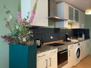a kitchen with a large vase with flowers in it at Skyline City Apartment in Berlin