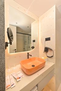 a bathroom with a sink and a mirror at Ira by Orchid Hyderabad Hitech City Mindspace IT Park in Hyderabad