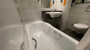 ドーハにあるPremier Inn Doha Education Cityの浴槽、洗面台、トイレを備えたバスルーム +69枚の写真