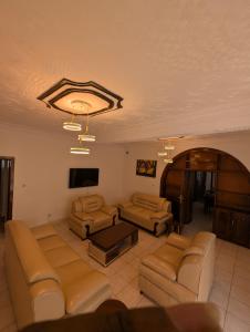 un salon avec des canapés et une télévision à écran plat dans l'établissement KiGALI EDDIE HOMES, à Kigali