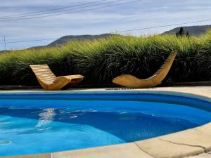 two chairs sitting next to a swimming pool at Pensiunea Casa Mircea & Restaurant in Eşelniţa