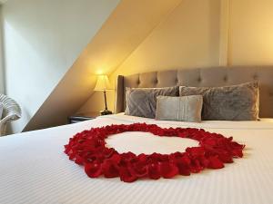 a heart made out of red roses on a bed at Arnica Views Summit Retreat in Mount Dandenong