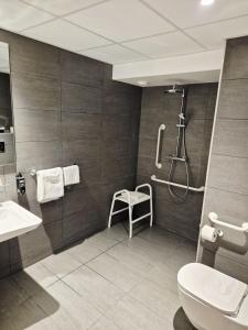 a bathroom with a shower and a toilet and a sink at Hôtel Morphée Lille Villeneuve d'Ascq in Villeneuve d'Ascq +39 photos