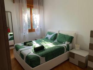 a bedroom with a bed with green sheets and a mirror at The Kaktus House - vicino San siro e Rho Fiera in Milan