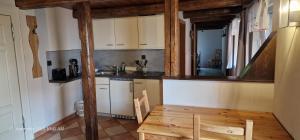 a kitchen with white cabinets and a wooden table and chairs at Pension Robinienhof in Schadeleben