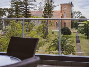 a balcony with a chair and a church at Mercure Centro Port Macquarie in Port Macquarie