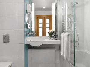 a white bathroom with a sink and a shower at Novotel Trabzon in Trabzon +257 photos