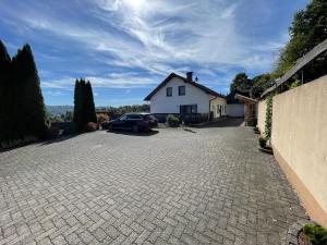 a driveway with a car parked in front of a house at Am Waldrand in Attendorn