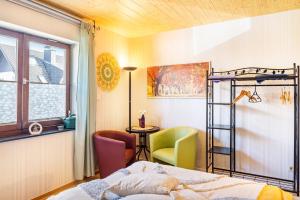 a bedroom with a bed and a chair and a desk at Ferienwohnung Energie und Balance in Lichtenau