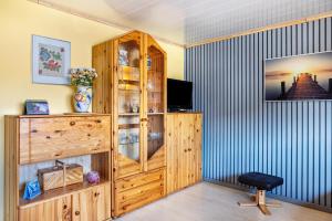 a room with a wooden cabinet and a television at Ferienwohnung Energie und Balance in Lichtenau