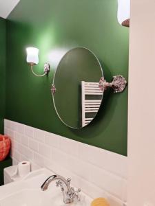 a bathroom with a mirror on a green wall at Maison chic du Jerzual in Dinan +19 photos