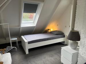a small bedroom with a bed and a window at Toekomst 27 - Ouddorp NOT INTENDED FOR COMPANY OR WORK-RELATED STAYS in Ouddorp