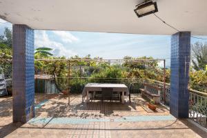 a patio with a table and benches on a balcony at Holidayshouse in Ercolano