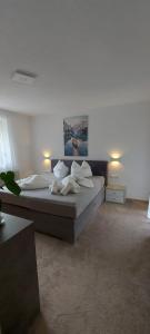ein Schlafzimmer mit einem Bett mit weißen Laken und Kissen in der Unterkunft Apartament Zaharia in Tumpen