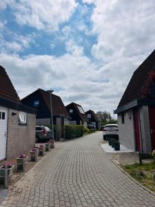 une allée en briques dans un quartier résidentiel avec des maisons dans l'établissement Het Coraaltje, à Julianadorp 17 autres photos