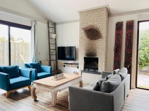 Elle comprend un salon doté d'un mobilier bleu et d'une cheminée. dans l'établissement Het Coraaltje, à Julianadorp