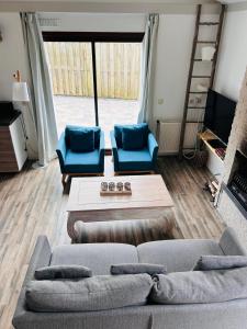 - un salon avec un canapé et deux fauteuils bleus dans l'établissement Het Coraaltje, à Julianadorp