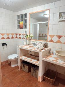 a bathroom with a sink and a toilet and a mirror at Alojamiento Rural Mi Frasca in Almodóvar del Río