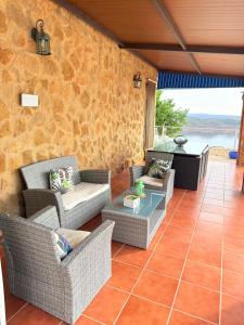 an outdoor patio with wicker chairs and a table at Alojamiento Rural Mi Frasca in Almodóvar del Río +30 photos