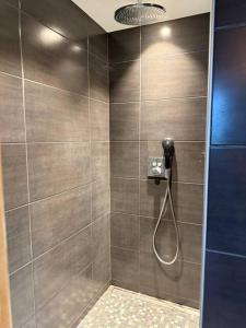 ein Badezimmer mit Dusche mit Duschkopf in der Unterkunft Beautiful chalet with swimming pool & great garden in Samoëns