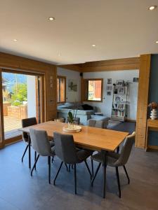 ein Esszimmer mit einem Holztisch und Stühlen in der Unterkunft Beautiful chalet with swimming pool & great garden in Samoëns